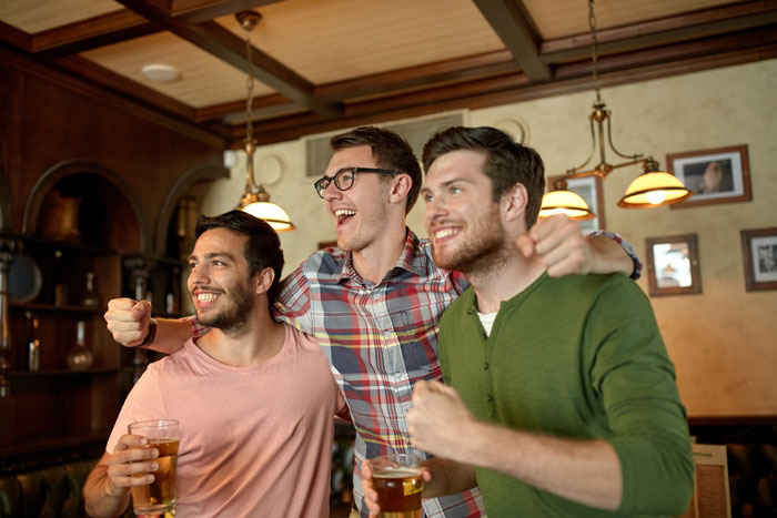 A group of men celebrating with their friends at a bachelor party.